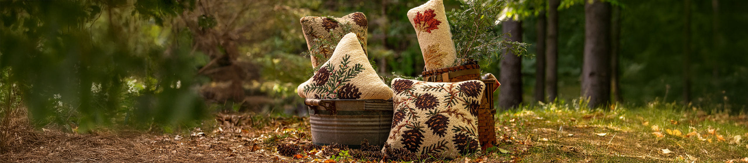 Chandler 4 Corners hand-hooked pillows pictured in a basket in the forest.