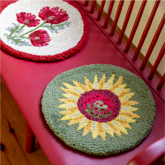 A collection of Chandler 4 Corners chair pads, pictured on a bench.