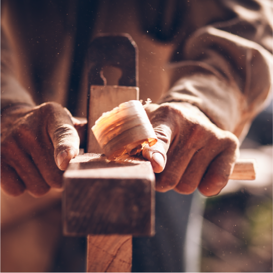 A craftsman using wood tools to carve furniture.